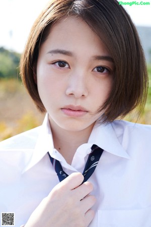 A woman in a school uniform posing for a picture.