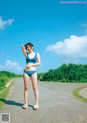 A woman in a blue shirt and green shorts posing for a picture.