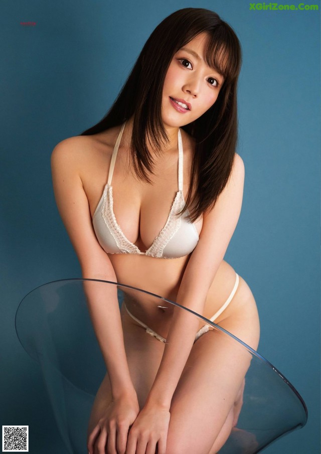 A woman in a white bra and panties sitting on a glass table.