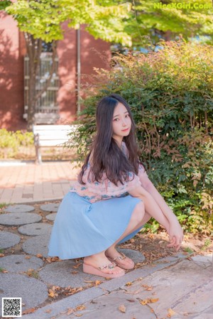 A woman sitting on the steps of a building.