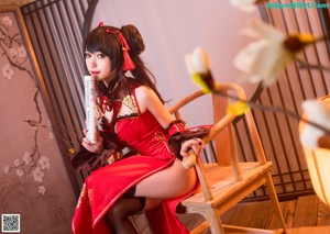 A woman in a red dress sitting at a table.