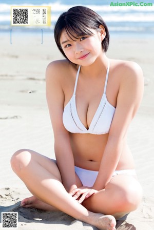 A woman in a blue bikini holding a basketball.