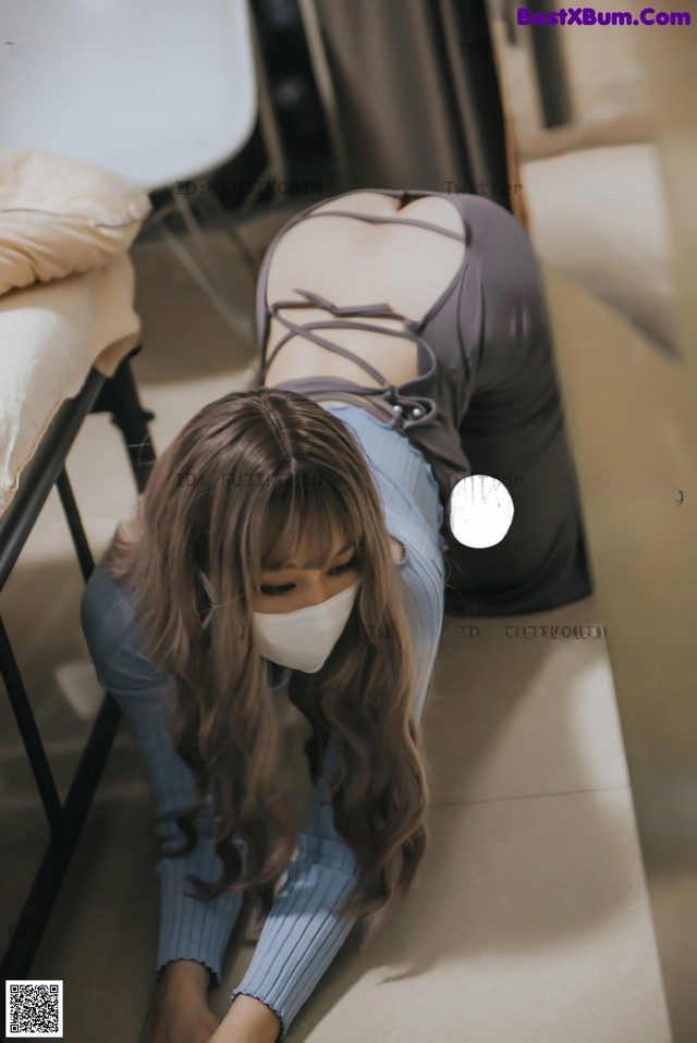 a woman wearing a face mask laying on the floor