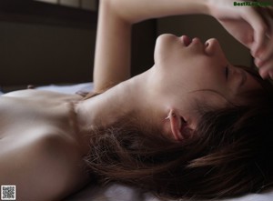 A close up of a pregnant woman laying on a bed.