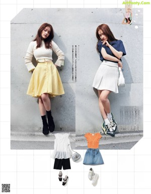 A woman leaning against a wall with a t-shirt and skirt.