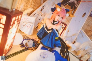 A woman in a blue and black outfit sitting on the floor.