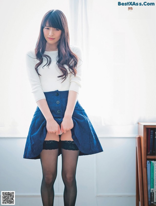 A woman in a skirt and stockings posing for a magazine.