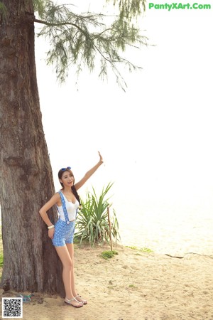 A woman in a blue and white dress holding a yellow flag.