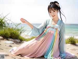 A woman in a colorful dress standing on a beach.