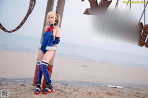 A woman in a blue and white outfit on a beach.