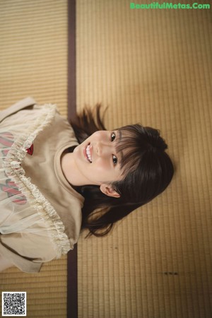 A woman laying on the floor in front of a window.