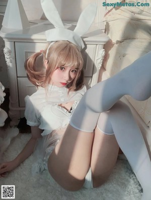 A woman in a bunny costume sitting on a toilet.
