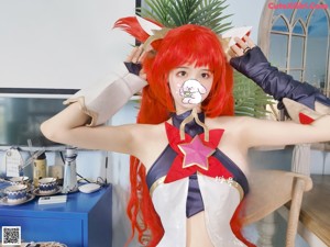 A woman with long red hair is posing for a picture.