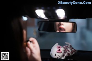 A woman sitting in the back seat of a white car.