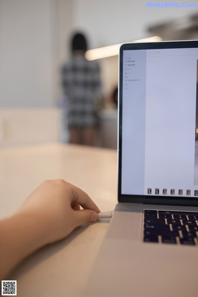 A person using a laptop computer on a table.