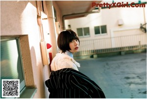 A woman sitting on a bed holding a piece of food.