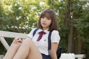 A young woman in a school uniform sitting on a bench.