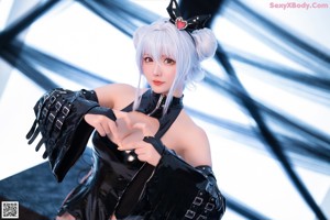 A woman in a black latex outfit posing for a picture.