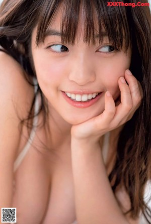 A woman in a black bikini sitting on a white surface.