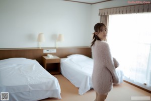 A naked woman in a pink sweater is posing for the camera.