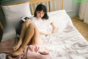 A woman in a red kimono sitting on the floor.