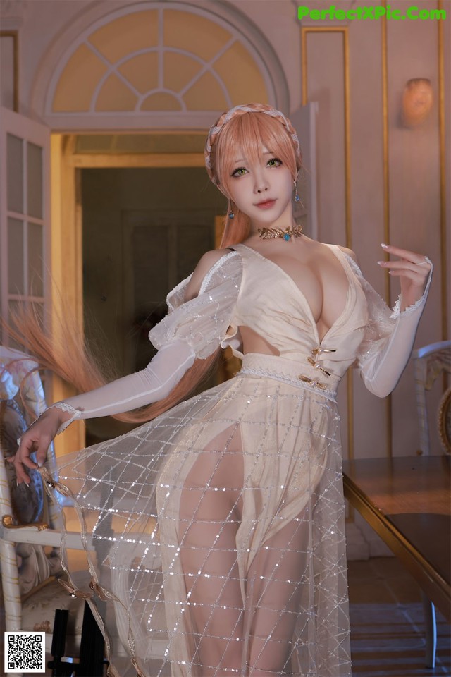 A woman in a white dress posing for a picture.