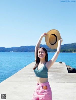 A woman standing on the edge of a body of water.