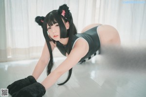A woman in a black and white outfit with cat ears.