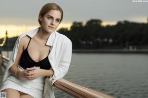 A nude woman sitting on top of a white couch.