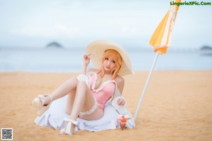 A woman in a pink bathing suit holding a cup of ice cream.