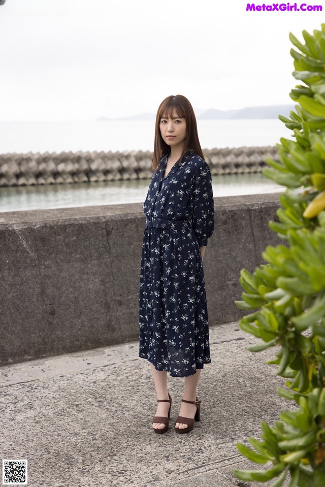 A woman standing in front of a body of water.