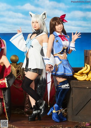 Two young women dressed in sailor outfits posing for a picture.