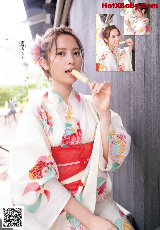 A woman in a kimono eating a popsicle.