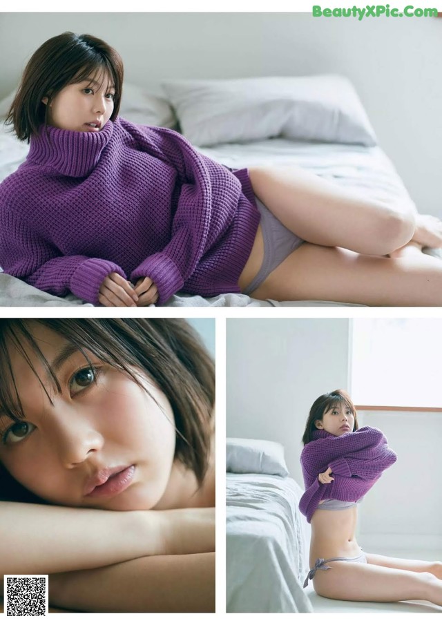 A woman in a purple sweater is laying on a bed.