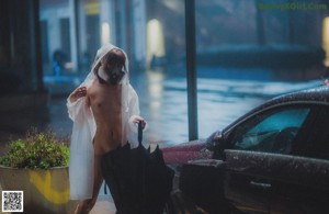 A woman standing in the middle of a street at night.