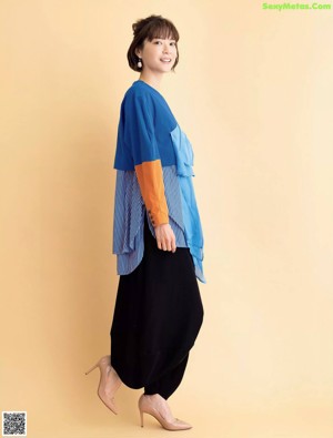A woman wearing a blue shirt and black pants.